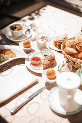 a table topped with plates of food and pastries at B&B Hotel Mair am Turm in Tirolo