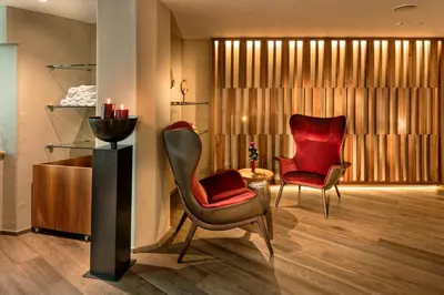 a living room with two chairs and a table at Romantik Hotel Oberwirt in Marlengo