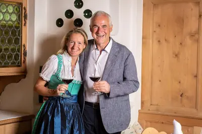 an older man and woman holding glasses of wine at Romantik Hotel Oberwirt in Marlengo