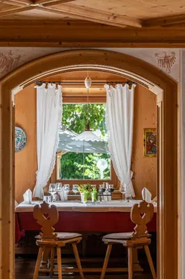 a dining room with a table and a window at Romantik Hotel Oberwirt in Marlengo
