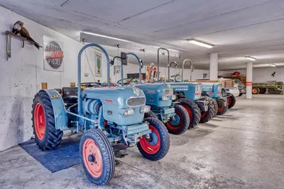 a row of blue tractors parked in a garage at Hotel Stefanie in Tirolo