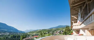 a view from the balcony of a building with mountains in the background at Hotel Weger in Tirolo