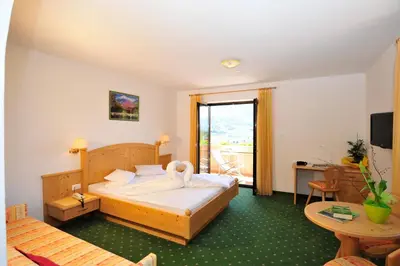 a hotel room with a bed and a table at Hotel Weger in Tirolo