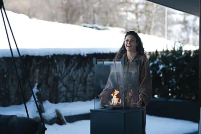 a woman standing next to a fire in a stand at Terentnerhof 4*S active & lifestyle hotel in Terento