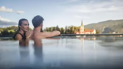 a man and a woman sitting in the water at Terentnerhof 4*S active & lifestyle hotel in Terento