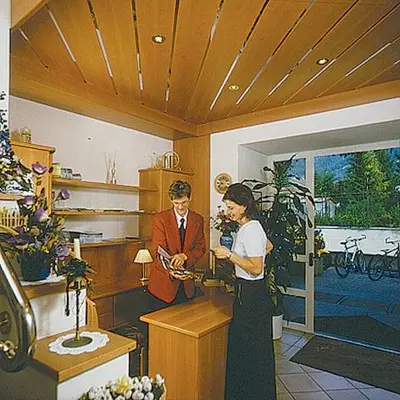 a man and a woman standing in a room at Hotel Residence Lorenz in Colle Isarco