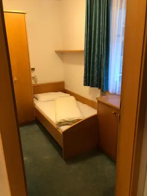 a small bed in a small room with a window at Hotel Residence Lorenz in Colle Isarco
