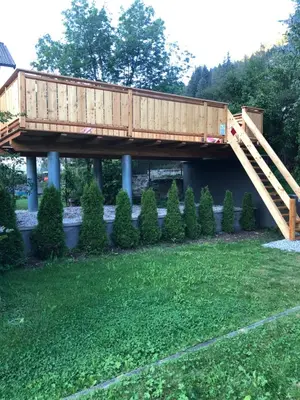 a wooden bridge in a yard with a lawn at Hotel Residence Lorenz in Colle Isarco