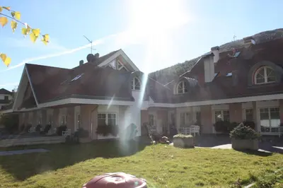 a large house with a dog in the yard at Hotel Residence Lorenz in Colle Isarco