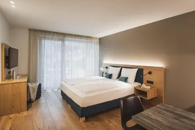a bedroom with a large bed and a table at Residence Nives in Bressanone