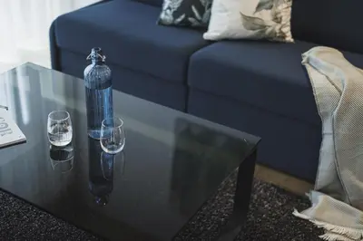 a black coffee table with two glasses and a bottle on it at Residence Nives in Bressanone