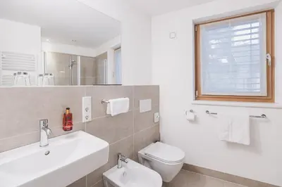 a white bathroom with a sink and a toilet at Residence Nives in Bressanone