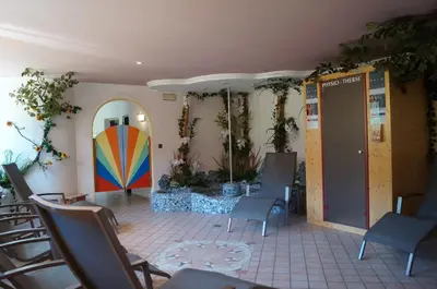 a room with chairs and a surfboard on the wall at Hotel Laurin in Tires