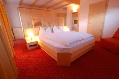 a bedroom with a large white bed with two lamps at Hotel Laurin in Tires