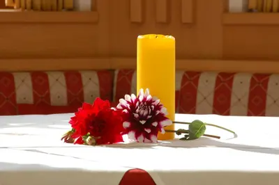 a candle and some flowers on a table at Hotel Laurin in Tires
