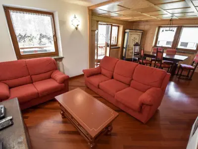 a living room with two red couches and a table at Chalet Cesa Galadriel-1 by Interhome in Penia