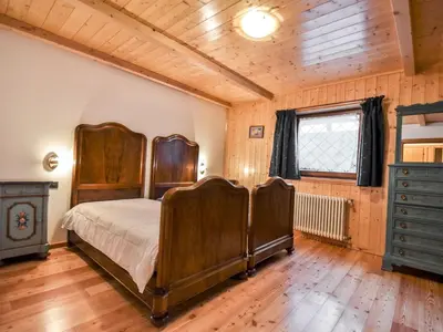 a bedroom with a bed and a wooden floor at Chalet Cesa Galadriel-1 by Interhome in Penia