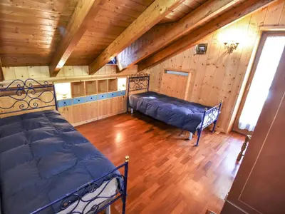 a room with two beds and a wooden ceiling at Chalet Cesa Galadriel-1 by Interhome in Penia