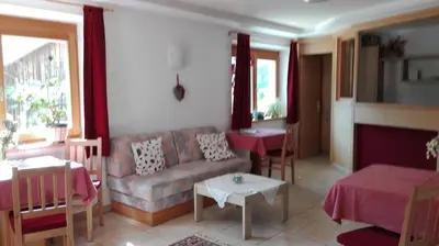 a living room with a couch and a table at Pensione Valbona in Corvara in Badia