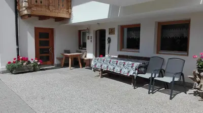 a patio with two chairs and a table and a table at Pensione Valbona in Corvara in Badia