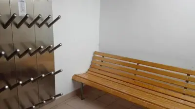a wooden bench sitting in a room next to a wall at Pensione Valbona in Corvara in Badia