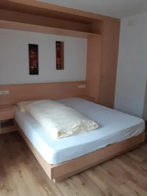 a bed in a room with a white bed frame at Pensione Valbona in Corvara in Badia