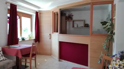 a living room with a fireplace and a table at Pensione Valbona in Corvara in Badia