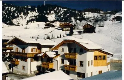 a large building with snow on top of a mountain at Pensione Valbona in Corvara in Badia