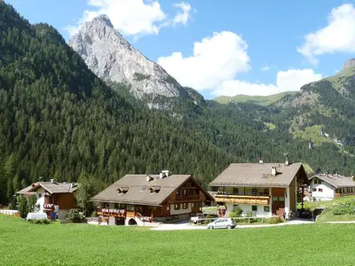 a view of a building with a mountain in the background at Apartment Cesa Galadriel-2 by Interhome in Penia