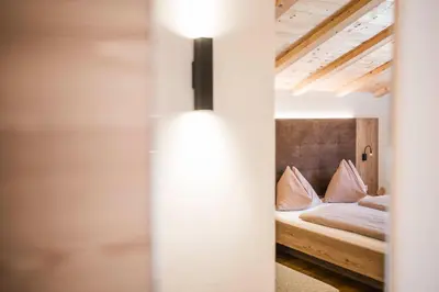 a bedroom with a bed and a light on the wall at Gasthof Jaufensteg in Racines
