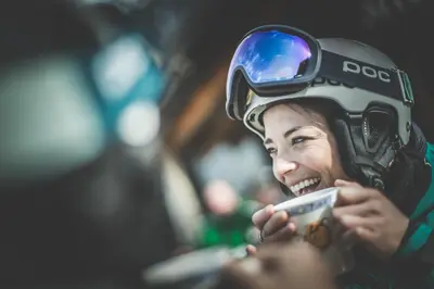 a woman wearing a helmet looking at her cell phone at Gasthof Jaufensteg in Racines
