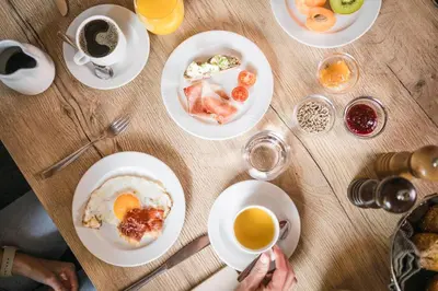 a table with plates of food and cups of coffee at Gasthof Jaufensteg in Racines