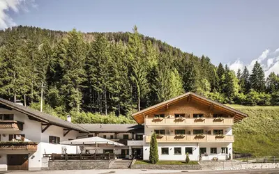 a large building with a mountain in the background at Gasthof Jaufensteg in Racines