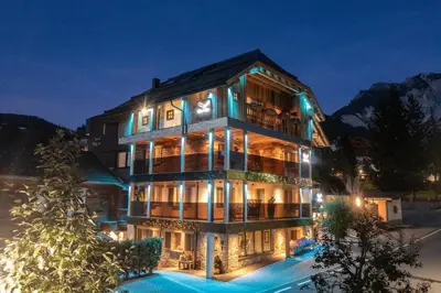 a large building with lights on it at night at Alpine Refuge Villa Adler in San Vigilio Di Marebbe