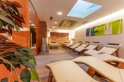 a waiting room with white chairs and a skylight at Alpine Refuge Villa Adler in San Vigilio Di Marebbe