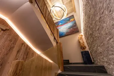a spiral staircase with a painting on the wall at Alpine Refuge Villa Adler in San Vigilio Di Marebbe