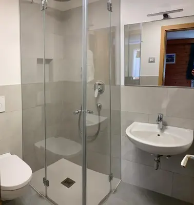 a bathroom with a shower with a toilet and a sink at CIADIN APPART. in Badia