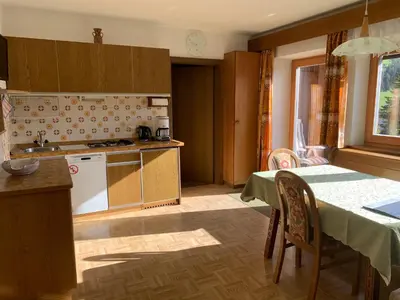 a kitchen with a table and a cross on the wall at CIADIN APPART. in Badia