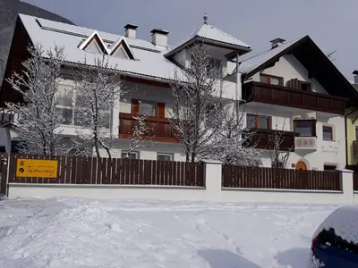 a house in the snow with a fence at App. Tamanhof in San Giorgio