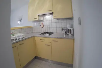 a kitchen with yellow cabinets and a stove at App. Tamanhof in San Giorgio