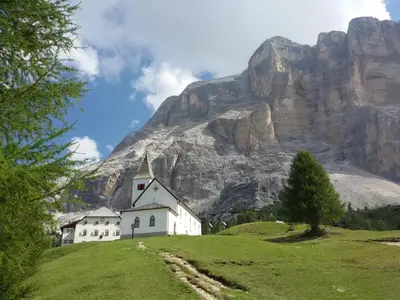 a church on a hill in front of a mountain at App. Tamanhof in San Giorgio