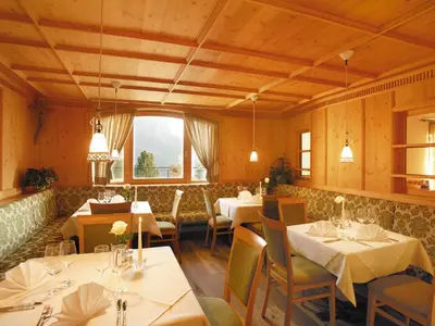 a restaurant with white tables and chairs and a window at Hotel Plunger in Castelrotto