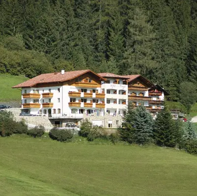 a large apartment building in the middle of a field at Hotel Plunger in Castelrotto