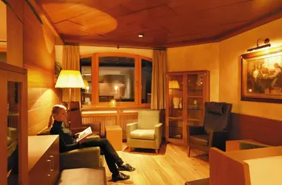 a man sitting on a chair in a room at Hotel Plunger in Castelrotto