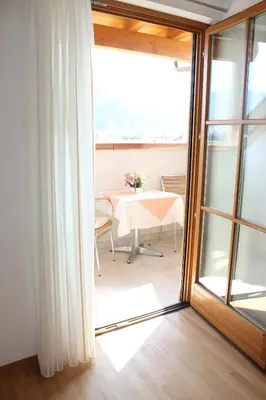 a room with a table and a glass door at Apartments Klotz in Bolzano