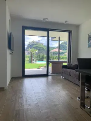a living room with a couch and a large glass door at Apartments Klotz in Bolzano
