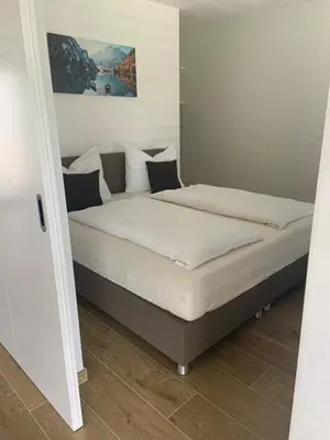 a bed with white sheets and pillows in a room at Apartments Klotz in Bolzano