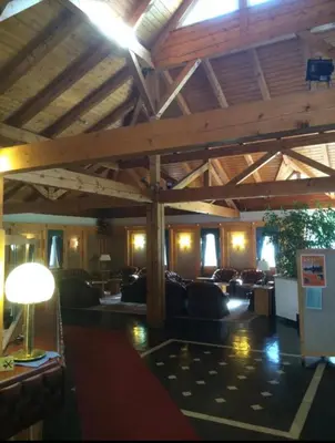 a large living room with couches and a wooden ceiling at Ploner villaggio Turistico in Dobbiaco