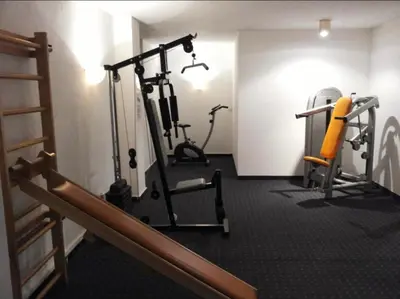 a room with a gym with a treadmill and weights at Ploner villaggio Turistico in Dobbiaco