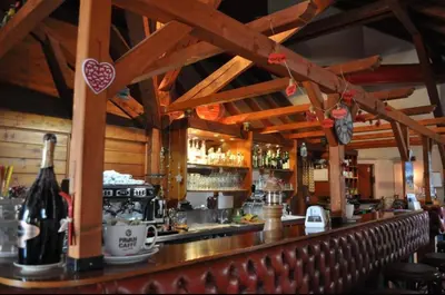 a bar with a counter with a bottle of wine at Ploner villaggio Turistico in Dobbiaco